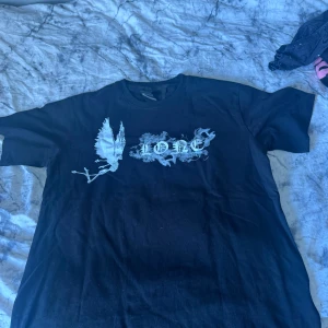 Vlone Tshirt  - En Vlone tshirt med ett stort ”V” och rökdetaljer. Sitter löst, kommer säkerligen krympa i tvätten