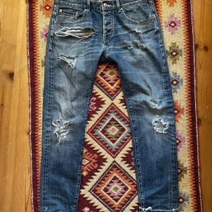 Selvedge jeans från Earnest Sewn med grym tvätt  - Riktigt snygga blå jeans från Earnest Sewn med riktigt snygga slitningar och hål på flera ställen (som är meningen) Jeansen har rak/slim passform, klassisk femficksdesign. Mycket snygga och ovanliga. Storleken står 32, passar bra för w30 l30-32. Vid minsta fundering är det bara att höra av sig!