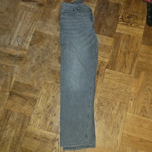 Grå raka jeans i storlek 30/34 jack and jones eddie  - Säljer ett par grå jeans med raka ben och klassisk femficksdesign. Jeansen har knappgylf och är i en snygg, neutral grå färg som passar till det mesta. Perfekta för dig som gillar en enkel och stilren look. Inte använda