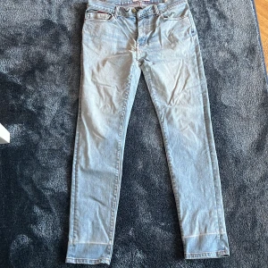 Ljusblå skinny jeans Tommy Hilfiger - Snygga ljusblå skinny jeans från Tommy Hilfiger Denim. Klassisk femficksmodell med dragkedja och knapp framtill. Jeansen har raka bakfickor med diskret logga och är tillverkade i mjukt denimtyg som sitter tight längs benen.