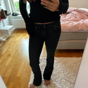 Svarta bootcut jeans - Snygga svarta jeans med bootcut passform och klassisk femficksdesign. Jeansen har låg midja och är tillverkade i ett mjukt denimtyg som sitter skönt. Perfekta för dig som gillar en avslappnad men trendig look.