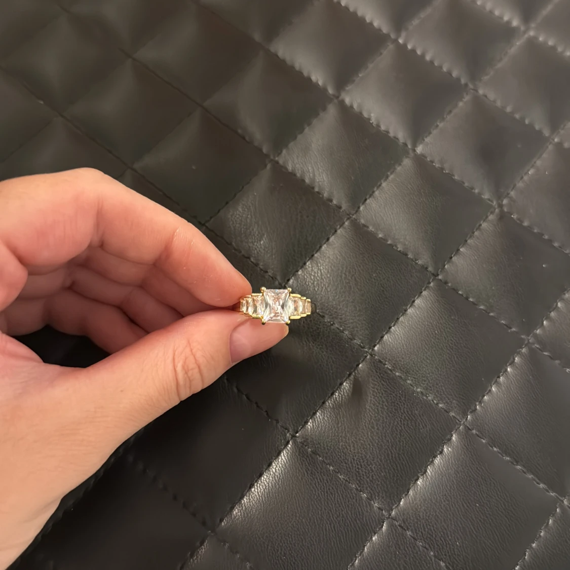 Guldfärgad ring med stor fyrkantig sten