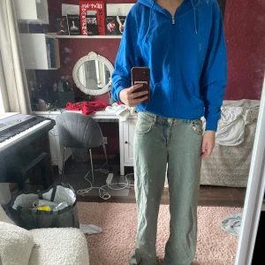 Blå hoodie från SOC med dragkedja - Blå hoodie från SOC i storlek S. Tröjan har huva, dragkedja framtill och två fickor. Tillverkad i mjukt material som känns skönt mot huden. Knappt använd.