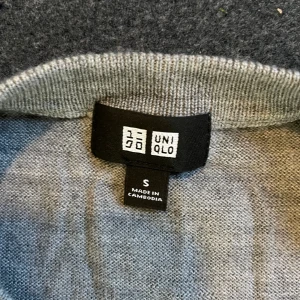 Uniqlo  - Säljer en stilren grå långärmad tröja från Uniqlo i 100% ull. Tröjan har rund halsringning och en klassisk, enkel design som funkar till allt. Perfekt för dig som gillar minimalistisk stil och vill ha något mjukt och bekvämt. Passformen lutar till slimfit är även en klassisk.