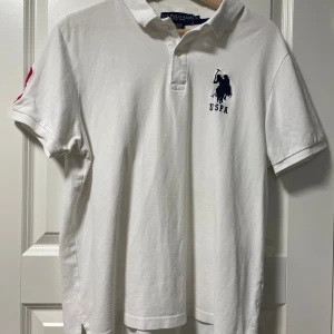 En snygg Vit pikétröja från U.S. Polo Assn - ✨ Klassisk Vit Pikétröja – U.S. Polo Assn (M) ✨  📏 Storlek: M 💰 Pris: 279 kr 🧼 Skick: Väldigt bra – använd bara ett fåtal gånger  Fräsch och stilren vit piké från U.S. Polo Assn – perfekt för sommarens alla tillfällen! Lätt att matcha, bekväm att bära och ger en tidlös, sportigt elegant look. 