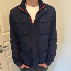 Tommy Hilfiger Field Jacka - Säljer denna feta Field jackan från Tommy hilfiger. Riktigt stilren och praktisk. Storlek M, modellen är 186cm 73kg.