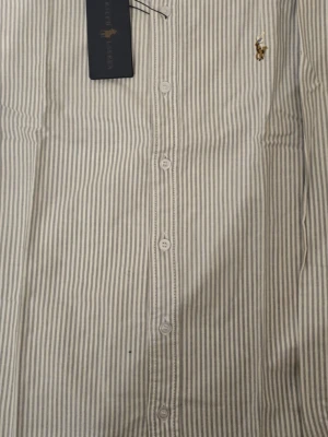 Polo Ralph Lauren randigt skjorta - Det är en mycket fin skjorta som är en a-kopi@ den är i storlek M gjord på bomull. Helt ny och priset kan diskuteras!!