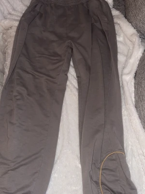 Kriminalvården, intagna kläder. Grå mjukisbyxor med gul detalj - Jag har ett par byxor och en tillhörande tröja och t-shirt från kriminalvården i storlek XL och  ett par byxor och t-shirt i storlek L. Säljer settet för 1700kr och det andra settet för 1300 köper man båda kan man få ett annat pris 