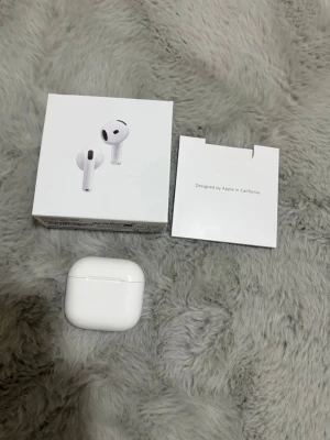 Apple AirPods 4 - Snygga och moderna Apple AirPods 4 med trådlös laddningsetui. Levereras especially med originalför Phase och dokumentation. Hörlurarna är i mycket gott skick, imed inga synliga repor eller skador. Perfekt för musik, samtal och träning med lång batteritid.