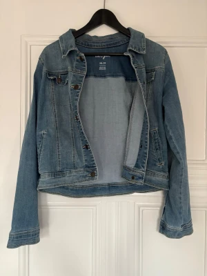 Blå jeansjacka från Cat & Jack Youth XXL,  dam S.)  - Säljer en klassisk  jeansjacka från Cat & Jack i storlek XXL. NOTERA: det är XXL youth men passar dam s/m i verkligheten. Jackan har  knappar framtill, bröstficka med knapp och oppna sidofickor. 