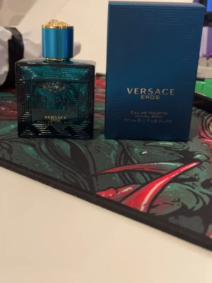 Versace Eros Eau de Toilette - Versace Eros Eau de Toilette, 50 ml. Ingredienser: Alcohol Denat, Aqua (Water), Limonene, Ethylhexyl Methoxycinnamate, Coumarin, Linalool, Alpha-Isomethyl Ionone, Citral, Geraniol, Cinnamal, Eugenol. Snygg design och ikonisk Versace-detalj på korken. Ungefär 45 ml kvar. Pris kan diskuteras.