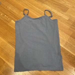 Grå linnetopp från Ullared, Gekås - Säljer en enkel och stilren blå linnetopp från gekås, Ullared . Toppen har smala, justerbara axelband och är tillverkad i mjuk bomull. 