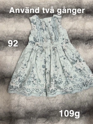 Blommig ljusblå klänning stl 92 - Supersöt ljusblå klänning med blommigt mönster och broderade detaljer. Ärmlös modell med rund hals och vackra spetskanter nertill. Perfekt för sommarens alla tillfällen och riktigt fin passform.🌸Använd två gånger. Storlek 92