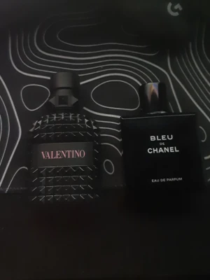 Valentino Uomo & Bleu de Chanel - Två ikoniska herrparfymer: Valentino Uomo Born in Roma (50 ml) och Bleu de Chanel Eau de Parfum. Snygga flaskor och populära val bland unga. Perfekt för dig som vill sticka ut med stil. Perfekt sommar parfymer! Skulle sägs att de är 65-70% kvar i båda Mer än hälften! Hör av er vid frågor eller nåt sånt!
