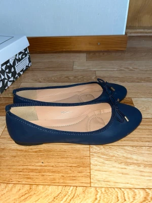 Mörkblå ballerinaskor med rosett - Snygga mörkblå ballerinaskor från DAY VINE med rund tå och dekorativ rosett framtill. Säljer då dom tyvärr är för små för mig❤️Använt fåtal gånger! 