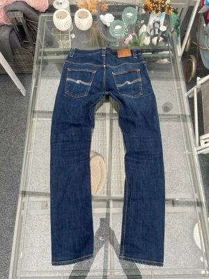 Nudie Jeans Thin Finn raw denim – W33 L34 - Säljer ett par Nudie Jeans Thin Finn i raw denim / Dry Ecru. Slim fit-modell med snygg rak passform. Gjorda i 100 % ekologisk bomull och formar sig snyggt efter kroppen över tid.  Storlek W33 L34. Använda men i bra skick, inga hål eller större slitningar. Perfekta om du gillar clean, minimalistisk stil eller streetwear.  Ett säkert val om du vill ha kvalitetsjeans som håller länge.  📦 Skickas snabbt 💬 Skriv vid frågor 