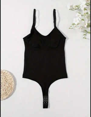 Svart ribbad bodysuit med kupor - Säljer en svart bodysuit med justerbara axelband och markerade kupor. Toppen är ribbad och har en tight passform med knäppning i grenen. Perfekt att styla med jeans eller kjol för en cool look. Ifrån Shein men materialet är extremt bra och skönt. Den passa tyvärr inte mig!