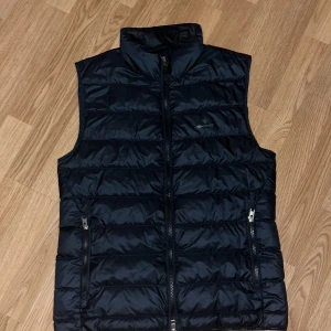Mörkblå dunväst från Gant - Fet Gant väst som är i mycket bra skick! Säljer då den blivit för liten. 