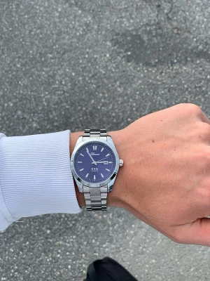 Silverfärgad blå klocka x Doventi - 🌟 Doventi - Helt ny och oanvänd klocka i toppskick! 🌟 🎁 Levereras komplett med originalbox. ✨ Perfekt skick, garanterat utan defekter. ⚙️ Enkel justering för optimal passform. 🚀 Snabb leverans samma dag – direkt till dig!