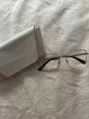 Michael Kors glasögon - Ett par Michael Kors glasögon med lightview styrka 1.5 på båda ögonen. Modellen Michael Kors MK3056 Naxos i färgen guld. Bågarna är tillverkade i metall och har en fyrkantig form. Har bevis på papper. 