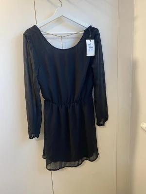 Svart klänning från Bik Bok - Svart klänning från Bik Bok men öppen rygg och snygg guldkedja som detalj 💫 Aldrig använd, nypris 299:-