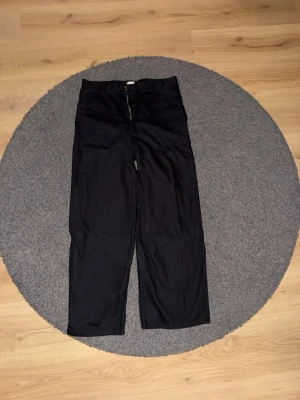 Svarta jeans ifrån Weekday - Säljer ett par svarta wide jeans från Weekday med klassisk dragkedja och knapp framtill. Byxorna har en rak och loose passform med hög midja. Materialet är bomull och de har en stilren look som passar perfekt till sneakers eller boots. Linen Blend jeans. Nypris 700kr aldrig använts.