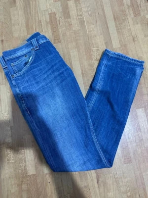 Dondup Campionario  - Säljer ett par klassiska blå jeans från Dondup med raka ben och fem fickor. Jeansen har snygga kontrastsömmar, samt Dondup-logga på bakfickan. Perfekt för dig som gillar en enkel och tidlös stil. Materialet är robust denim.