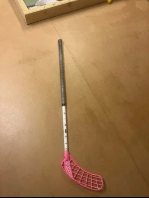 Zone innebandyklubba med rosa blad - Säljer en innebandyklubba från Zone med ett snyggt rosa blad och vit skaft. Greppet är grått och har en skön känsla i handen. Bladet har Zone-loggan och är lätt böjt för bättre bollkontroll. Perfekt för dig som vill sticka ut på planen! Med Skills, 88cm lång nypris 1300kr mitt pris 495 hör av er vid frågor mvh Nils 