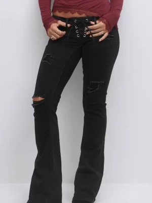 Svarta low waist  bootcut jeans med snörning - Säljer ett par svarta jeans från Gina tricot med bootcut-snitt och cool snörning i midjan. Byxorna har slitna detaljer och hål vid knät. Byxorna är beställda i Fel storlek vilket betyder att dem är sprillans ny och som man ser på bilden är byxorna kvar i ett oöppnad packet.Det är bara att höra av sig om man har några funderingar 💕