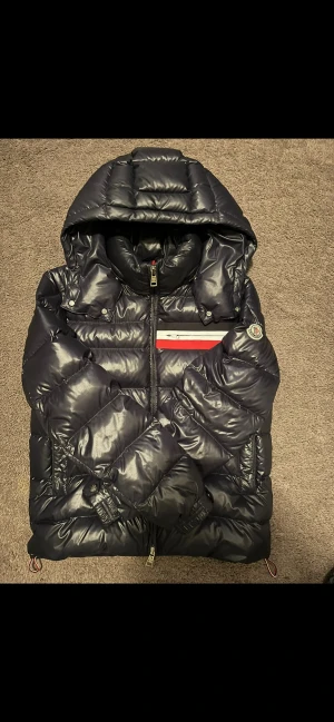 Moncler Jacka - Säljer denna sällsynta Moncler jacka som är perfekt nu inför kyligare dagar, den är väldigt sparsamt använd men det finns inga skador eller tecken på användning, skick 9-9.5/10. Självklart äkta samt finns ett äktehetscertifikat från Garmsmarket✅ Vid fler frågor och funderingar så är det bara att skriva🤝