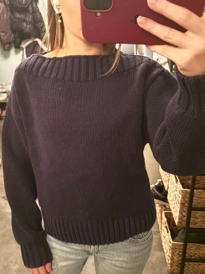 Mörkblå stickad tröja Gina Tricot - Säljer en mörkblå stickad tröja från Gina Tricot i storlek XS. Tröjan har bred ribbad kant vid halsringning, ärmslut och nederkant. Modellen är loose fit med långa ärmar och passar perfekt till jeans. Superenkel att styla och riktigt skön.