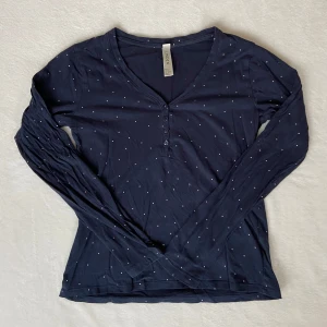Prickig pyjamas tröja - Säljer en prickig mörkblå pyjamaströja från Lindex. Har knappt andvänt!! Tröjan har en V-ringning framifrån med söta knappar. Andra bilden är inte min, utan den är från lindex hemsida 🫶🏼Skriv vid intresse 💗 