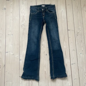 Mörk blå low waist bootcut jeans - De är uppsprättade där nere på benen därför är de cirka 2 cm längre.