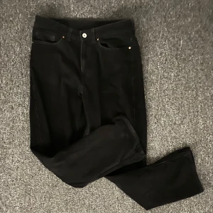 Svarta manchesterbyxor valient  - Svarta manchesterbyxor med klassisk femficksdesign och raka ben. Byxorna har tydliga ribbor i tyget, bälteshällor och knappstängning framtill. Baktill finns två stora fickor. Perfekta för dig som gillar retrovibe och vill ha något som sticker ut. Storlek xs.