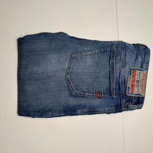Blå jeans från Diesel, straight fit - Tja säljer nu dessa stilrena jeans. Modellen har raka ben och normal passform. Perfekt för dig som gillar stilrena och tidlösa jeans.