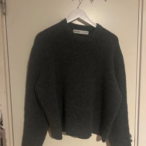 Mörkgrå stickad tröja från Bershka - Mysig mörkgrå stickad tröja från Bershka med rund halsringning och lång ärm. Perfekt för lager-på-lager och chill höst- eller vinterstil. Enkel och stilren design som funkar till allt. Säljes i storlek S.