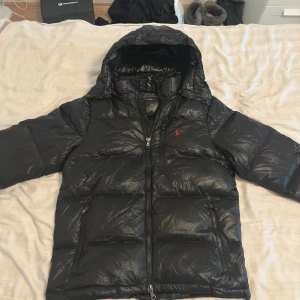 Ralph Lauren Glossy jacka  - Ralph Lauren Glossy jacka i storlek Medium. Jackan är helt oanvänd och i nyskick utan defekter. Säljes då den inte kommer till användning. Kvitto finns. Hör gärna av dig vid frågor eller funderingar! 