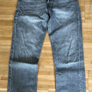 Grå relaxed jeans 29/32 - Säljer ett par grå jeans i relaxed fit med raka ben och klassisk femficksdesign. Jeansen har en snygg tvättad look och är tillverkade i slitstarkt denim. 