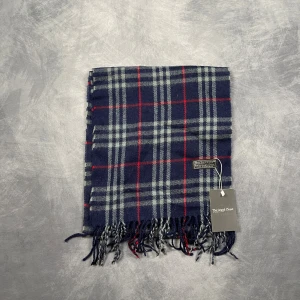 Burberry Halsduk - Skick: 7/10 (Vintage), begagnad, inga defekter. | Vad som ingår: Endast halsduken. | Ordinarie pris: +- 4000 SEK / 400 €. | ​​OBS: Halsdukarna finns i samma färgsättning men kan skilja sig något i modell eller detaljer, beroende på tillverkningsår eller kollektion