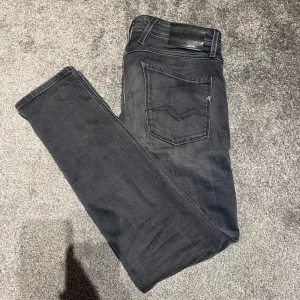 Replay Anbass svarta slim jeans 32/32 - Svarta Replay Anbass jeans i slim fit med klassisk femficksdesign och snygga slitningar. Jeansen har en mörk tvätt och diskreta detaljer på bakfickan. Perfekta för dig som gillar en smalare passform och stilren look. Köpt på zalando som man kan se på sista bilden.