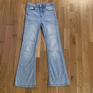 Ljusblå jeans från LAB Industries - Snygga ljusblå jeans från LAB Industries i bootcut-modell. Jeansen har klassisk femficksdesign, bälteshällor och knappgylf. Tillverkade i mjukt denim med en schysst tvättad look. Perfekta för dig som gillar en avslappnad och trendig stil.anndvända få gånger