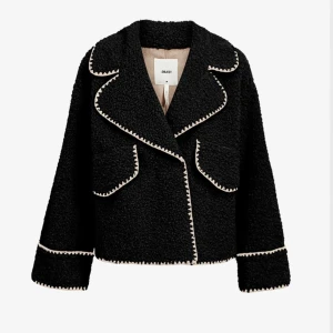 Svart teddyjacka från Object - Svart teddyjacka med vita broderade kanter, oversized krage och stora fickor framtill. Jackan har en oversized passform. Endast använd fåtal gånger💕Nypris 1199 kr