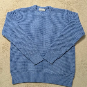 Blå stickad tröja från Cotton & Silk - Säljer en blå stickad tröja från Cotton & Silk i storlek M. Tröjan har ett grovt, strukturerat stickmönster och rund halsringning. Perfekt för dig som gillar en klassisk och enkel stil med lite extra textur. Den är välskött och i bra kvalité! 