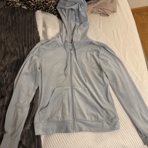 Ljusblå velourhoodie från Gina Tricot - Mjuk och skön ljusblå hoodie i velour från Gina Tricot. Tröjan har dragkedja framtill, huva med snörning och två fickor. Perfekt för en chill och avslappnad stil.