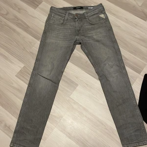 Replay grå jeans slim - Snygga grå jeans från Replay med klassisk femficksdesign och raka ben. Jeansen har en normal passform och är tillverkade i slitstarkt denimmaterial. Perfekta för dig som gillar en enkel och stilren look.