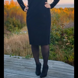 Svart stickad klänning Esprit stl M  - Svart stickad klänning Esprit stl M  Elegant svart klänning med långa ärmar och en dekorativ krage med strass. Klänningen har en figurnära passform och en längd som når till knäna. Detaljer med dekorativa knappar på ärmarna. Normal M  85% viscose  15% polyester