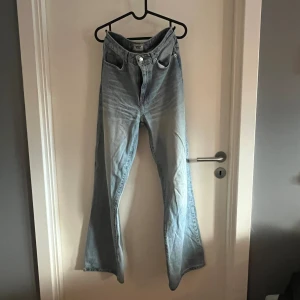  jeans från Lager 157 Boulevard - Ljusblå jeans från Lager 157 Boulevard med klassisk femficksdesign och knappstängning. Jeansen har en hög midja och är tillverkade i mjukt denimtyg som ger en skön känsla. 