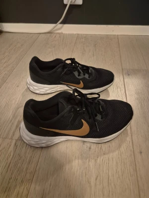 Svarta Nike sneakers - Svarta Nike sneakers med guld märke