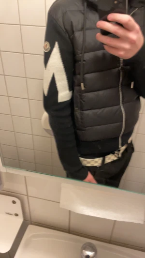 Svart Moncler pufferjacka med huva - Storleken är M men passar också S, Säljer en svart pufferjacka (cardigan) från Moncler med stickade ärmar och stor vit detalj på ena ärmen. Jackan har huva med snörning, dragkedja framtill och två fickor med knappar. Klassisk Moncler-logga på ärmen och cool, säljer den för den inte passar mig längre! Priset kan diskuteras. 