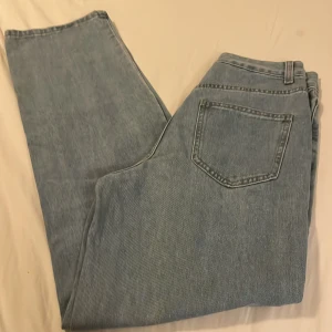 Ljusblå raka jeans från SHEIN XS - Säljer ett par ljusblå jeans från SHEIN i storlek XS. Modellen har raka ben, klassisk femficksdesign och bälteshällor. Jeansen är tillverkade i bomull och har en enkel knappstängning framtill. Perfekt för dig som gillar en clean och avslappnad look.